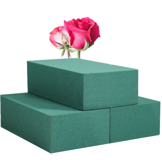 Three green floral foam blocks stacked with a pink and white rose placed on top