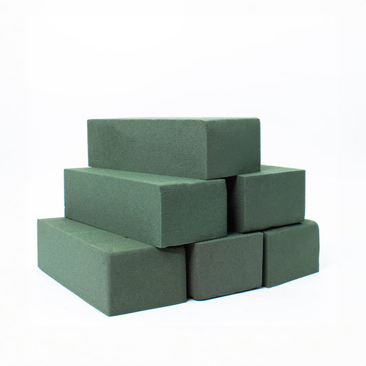 A stack of rectangular green floral foam blocks on a white background.
